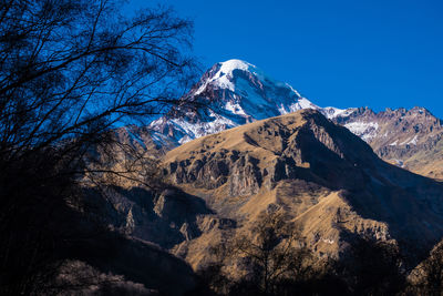 Scenic view of snowcapped mountains against clear blue sky