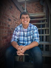 Portrait of smiling young man sitting on steps