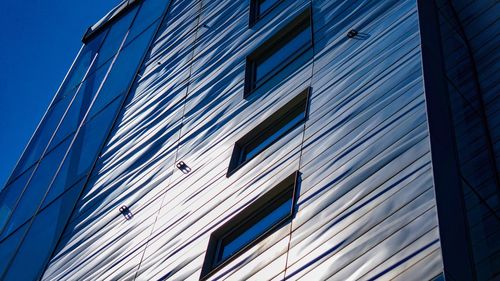 Low angle view of modern building against blue sky
