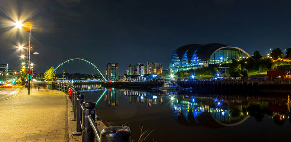 Illuminated bridge over river at night