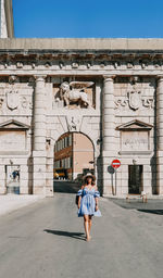 Full length of woman walking against building in city