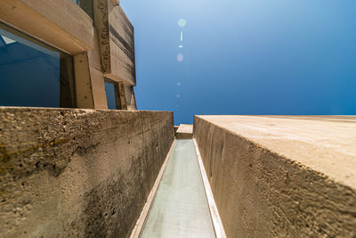 Street amidst buildings against clear blue sky