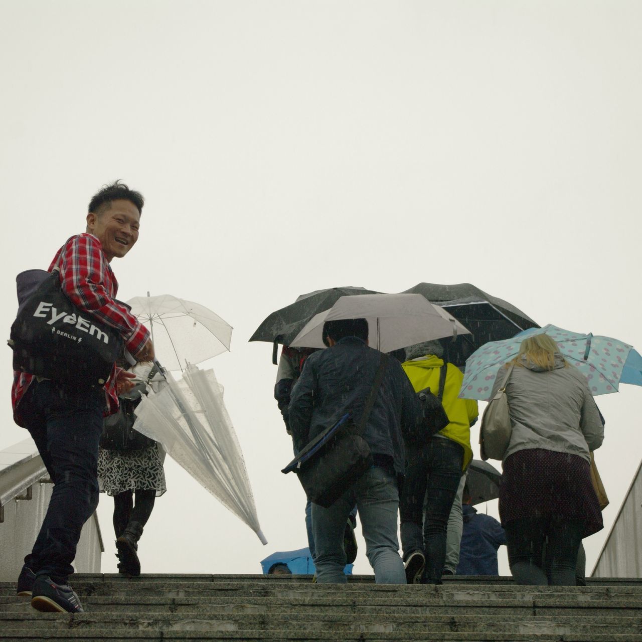 clear sky, copy space, lifestyles, leisure activity, full length, men, rear view, casual clothing, standing, person, built structure, walking, architecture, warm clothing, umbrella, togetherness