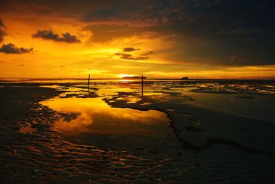 Scenic view of sea against dramatic sky during sunset