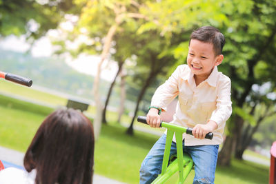 Mother with son sitting on seesaw in park