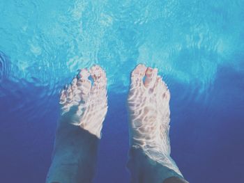 Low section of person swimming in pool