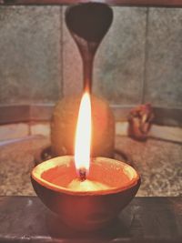 Close-up of lit candle on table