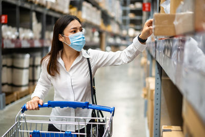 Woman with umbrella standing in store