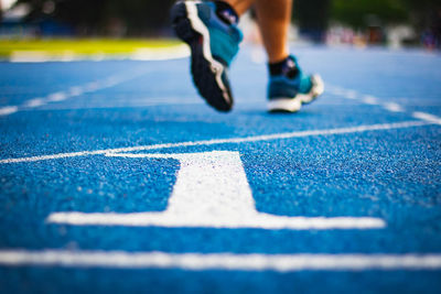 Low section of man running on running track