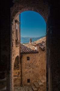 Old building against sky seen through window