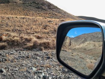 Reflection of side-view mirror on field