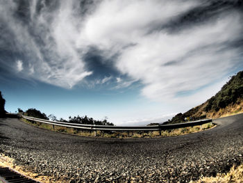 Scenic view of road by mountains against sky