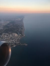 Aerial view of sea and cityscape against sky