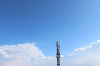 Low angle view of communications tower against blue sky