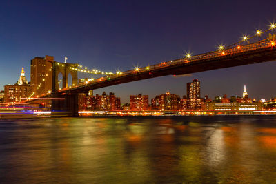 View of manhattan at dusk with the brooklyn bridge in the foreground