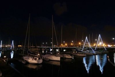 Boats moored in river at night