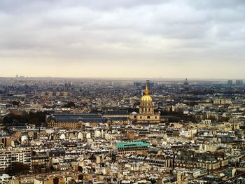 Aerial view of cityscape against cloudy sky