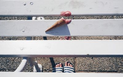 Low section of person standing by ice cream fallen on table