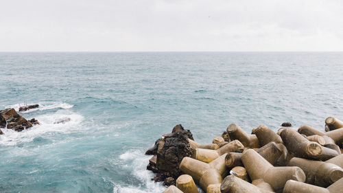 Rocks on sea shore against sky