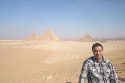 Man standing against giza pyramid complex