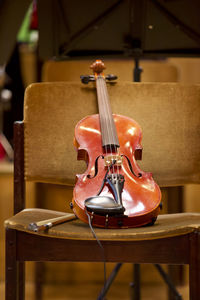 Close-up of violin on wooden chair