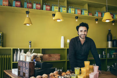 Portrait of happy man with vegetables on table