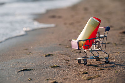 Close-up of shopping cart on beach