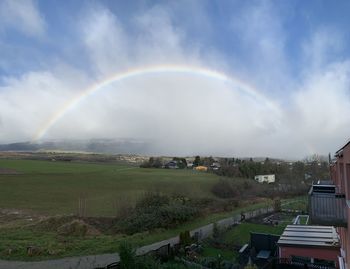 Scenic view of rainbow over field against sky