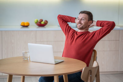 Charismatic happy glad man freelancer working at laptop at home, happy at successful project ending