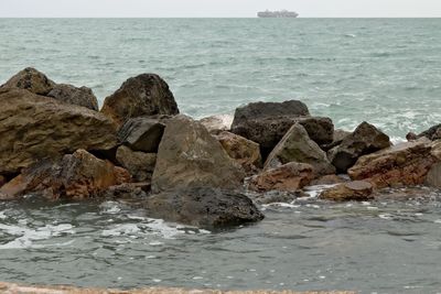 Rocks on sea shore against sky