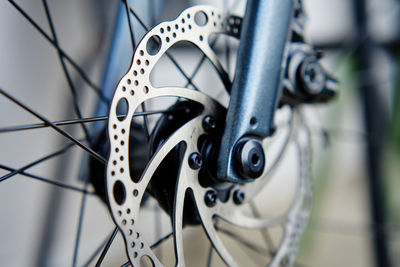 Part of the bicycle's braking system. grey metal brake disc and brake pads on road bike, close up.