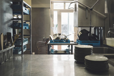 Plates arranged on kitchen counter in restaurant