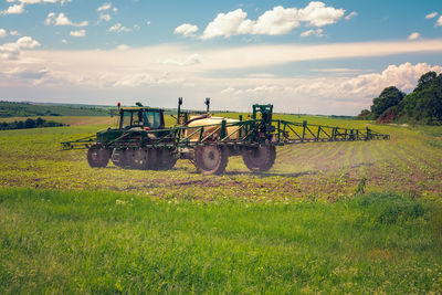 Farm machinery spraying insecticide to the agricultural field