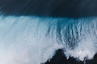 Powerful foamy sea waves rolling and splashing over water surface against cloudy blue sky