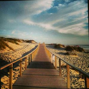 Empty road against cloudy sky