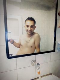 Portrait of shirtless man in bathroom