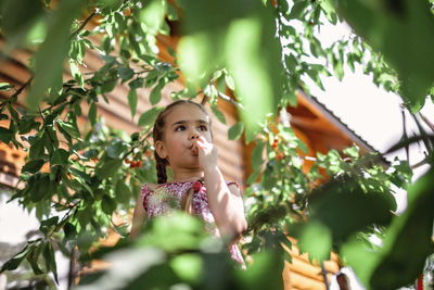 Portrait of girl with leaves on tree