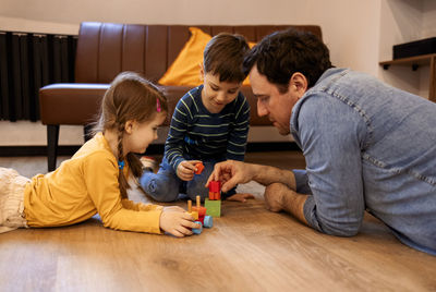 Boy playing with toy on floor at home