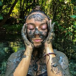 Woman having mud bath in forest