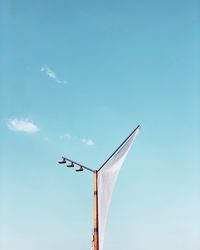 Low angle view of crane against blue sky