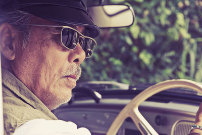 Close-up of senior man driving car