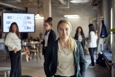 Portrait of blond businesswoman standing standing at creative office