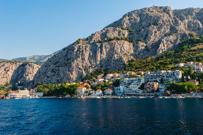 Scenic view of sea by buildings against sky