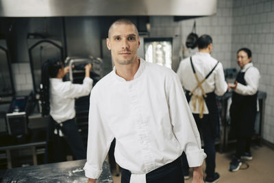Portrait of young man standing in factory