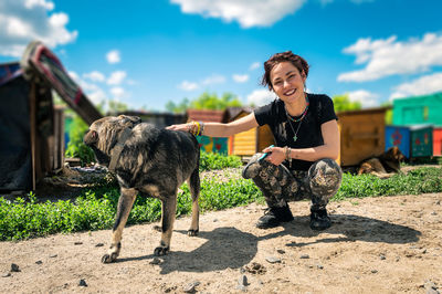 Dog at the shelter.  lonely dogs in cage with cheerful woman volunteer