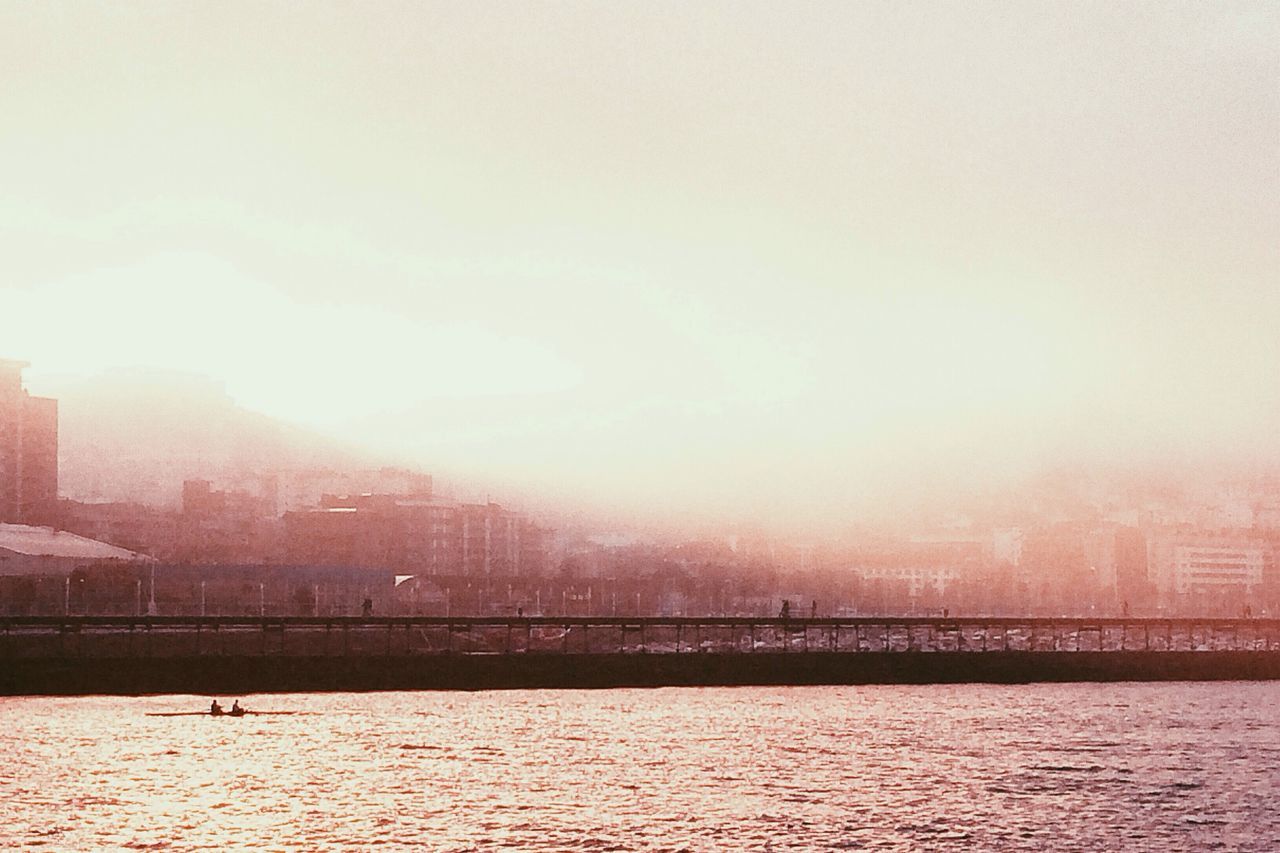 built structure, architecture, connection, bridge - man made structure, waterfront, water, river, building exterior, bridge, city, engineering, sky, transportation, clear sky, sunset, copy space, outdoors, suspension bridge, no people