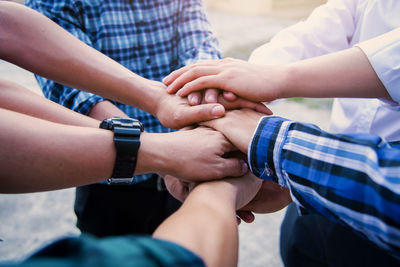 Midsection of people holding hands