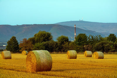 Hay bales on field against sky