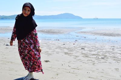 Portrait of young woman standing on beach