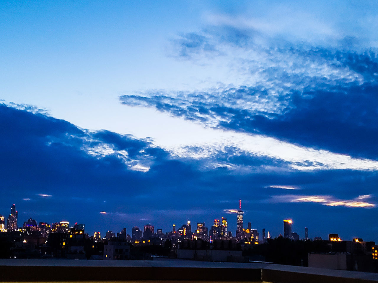 VIEW OF CITY AGAINST CLOUDY SKY AT DUSK